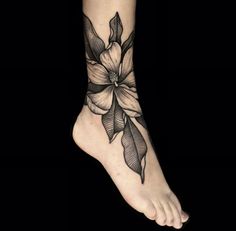 a black and white flower tattoo on the foot