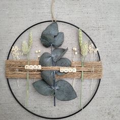 a metal circle with some flowers and leaves on it