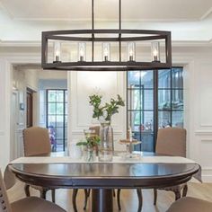 a dining room table with chairs and a chandelier hanging from it's ceiling