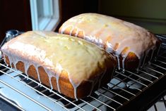 two loafs of lemon pound cake sitting on top of a cooling rack next to each other