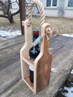 a wine bottle holder made out of wood and rope