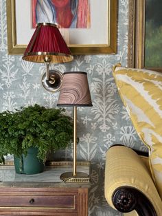 a living room with a couch, table lamp and painting on the wall behind it