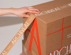 a person's hand reaching into a cardboard box