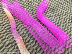 two pieces of pink and orange mesh sitting on top of a table next to each other