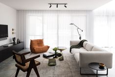 a living room filled with furniture and a flat screen tv mounted on the wall above it