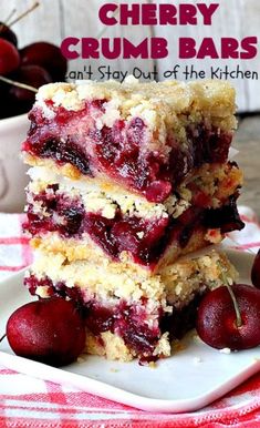 cherry crumb bars stacked on top of each other with cherries in the background