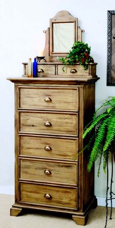 a wooden dresser sitting next to a potted plant