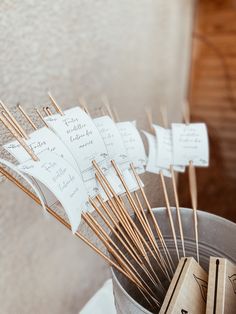 there are many wooden sticks sticking out of a cup with notes on them and some matches