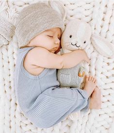 a baby is sleeping next to a stuffed animal