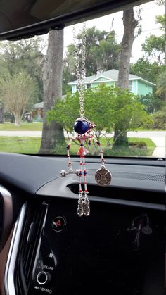 a car dashboard with a key chain hanging from it's center console, and a house in the background