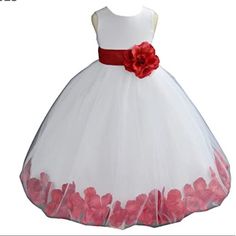 a white dress with red flowers on the bottom and pink petals at the waist, in front of a white background