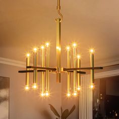 a chandelier with lights hanging from it's sides in a living room