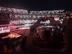 people are taking pictures with their cell phones in front of the crowd at a concert