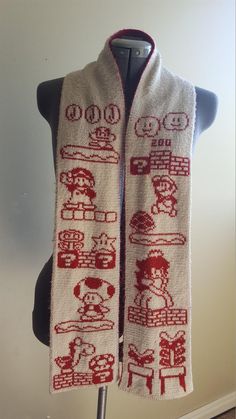 a knitted scarf with images of people and vehicles on it, sitting on a mannequin