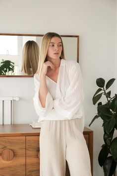 The Sade top’s surplice silhouette adds a romantic cross-front drape to a tunic body. An elongating vertical stripe cascades down its length. Flowing material feels irresistibly breezy with wide sleeves and a low back hem. It’s perfect for strolls in the sand or layering over a transitional look. A soft-tailored collar adds “boyfriend shirt” appeal, while an optional invisible closure lets you wear it more modestly. - Wide sleeves- Surplice front drape- Optional closure- 100% Turkish cotton- One Versatile V-neck Blouse For Loungewear, Striped V-neck Blouse For Daywear, Striped V-neck Blouse With Relaxed Fit, Striped V-neck Relaxed Fit Blouse, Striped Relaxed Fit V-neck Blouse, Drape Top, Soft Tailoring, Surplice Top, With Boyfriend