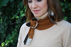 a woman wearing a knitted scarf with a fox on it's neck,