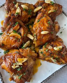 chicken wings with almonds and parsley on a white platter, ready to be eaten