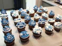 cupcakes decorated with blue and white frosting are arranged on a counter top