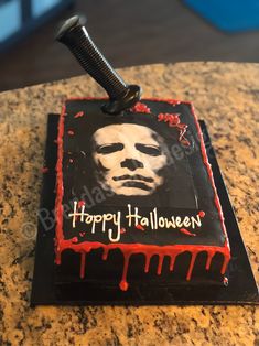 a birthday cake with a knife sticking out of it's face and the words happy halloween on it