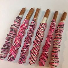 several pink and white candy sticks are lined up