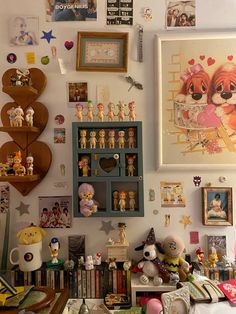 there are many pictures on the wall above the bookshelf and other things in the room