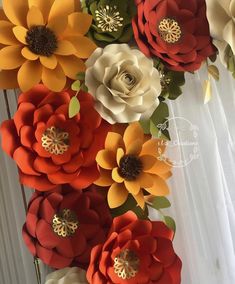 paper flowers are arranged on the side of a wall