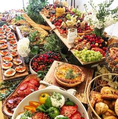 a table filled with lots of different types of food on wooden trays next to each other