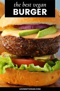 a hamburger with lettuce, tomato and avocado on it is shown