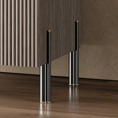 two black and gold poles on the floor next to a radiator in a room