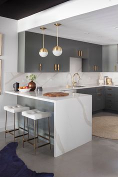 a kitchen with grey cabinets and white countertops is featured in the article 6 ways to take a basic builder - grade condo