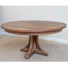 a round wooden table with two leaves on the top and one leaf at the base