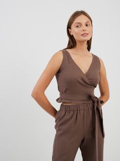 "EVA is a true wrap linen crop top. DETAILS - True wrap closure - Sleeveless design - Crop style - Oeko-Tex certified 100% midweight linen - Cut and sewn to order just for you in our studio COLOR - Cocoa, you can also choose other colors above - Fabric samples are available here https://www.etsy.com/listing/586569696/linen-fabric-samples SIZING & FIT - Fits true to size - Model is 5'10\" / 178cm and wearing a size S CARE FOR LINEN - Machine wash up to 30ºC/86ºF gentle cycle - Lay flat to dry or tumble dry low - Warm iron if needed - Do not bleach SIZE GUIDE Size conversion guide Size XS (US 0-2, IT 36-38, UK 4-6, Japan 3-5, France 32-34) Size S (US 4-6, IT 40-42, UK 8-10, Japan 7-9, France 36-38) Size M (US 8-10, IT 44-46, UK 12-14, Japan 11-13, France 40-42) Size L (US 12-14, IT 48-50, UK Versatile Cropped Linen Tops, Fitted Linen Wrap Top, Fitted Linen V-neck Wrap Top, Chic Sleeveless Linen Crop Top, Chic Fitted Linen Wrap Top, Fitted Linen Top With Tie Waist, Fitted Linen Tops With Tie Waist, Summer Linen V-neck Crop Top, Summer Linen Crop Top With V-neck