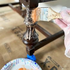 someone using a brush to paint a piece of furniture