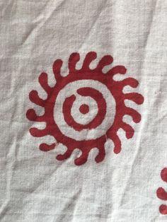 red and white fabric with an image of a spiral design in the center on it