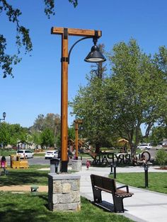 a park bench sitting on top of a lush green field next to a light pole