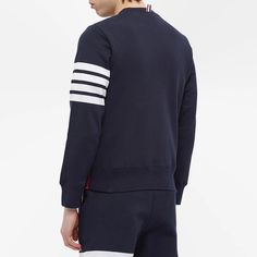 This navy blue sweater from.Thom Browne.is equal parts elegant and sporty. It teams premium cotton jersey with ribbed trims for all-day comfort, while the American designer’s iconic four-bar branding on the left sleeve and tricolour taping in the side seam complete the look..100% Cotton.Woven Brand Patch.Ribbed Trims.Made in Japan.Model is 6ft/1.82m with a 35.5”/90.2cm chest and wears a size 2. Sporty Cotton Sweater With Logo Detail, Sporty Crew Sweater With Logo Detail, Sporty Crew Neck Sweater With Logo Detail, Sporty Fall Sweater With Logo Detail, Sporty Logo Sweatshirt For Loungewear, Sporty Sweatshirt With Logo For Loungewear, Navy Winter Tops With Logo Detail, Classic Navy Sweatshirt With Ribbed Cuffs, Classic Navy Tops With Ribbed Cuffs