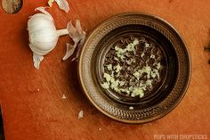 an onion and other food items on a wooden cutting board next to garlic florets