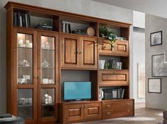 a living room filled with furniture and a flat screen tv on top of a wooden entertainment center