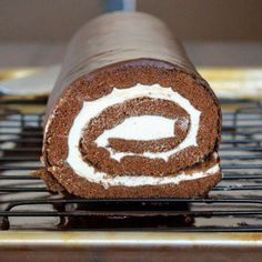 a cake roll sitting on top of a cooling rack with the words how to make a swiss cake roll