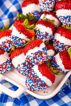 strawberries with red, white and blue sprinkles are arranged on a plate