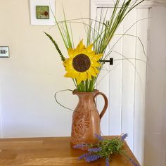 a vase filled with yellow flowers on top of a wooden table