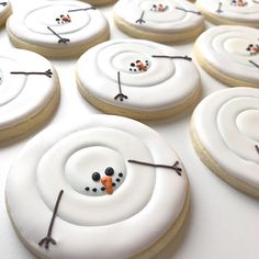 decorated cookies with frosting are arranged in the shape of a snowman