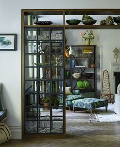 a living room filled with lots of furniture and decor on top of wooden flooring