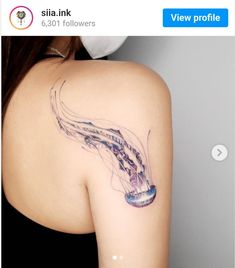 a woman with a tattoo on her shoulder that has a jellyfish in the water