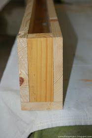 a piece of wood sitting on top of a white cloth covered floor next to a wooden bench