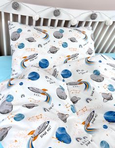 an image of a child's bed with space themed sheets and pillowcases