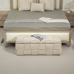 a bedroom with a large bed and footstool on the floor in front of it