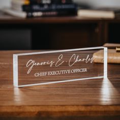 a clear acrylic sign sitting on top of a wooden table