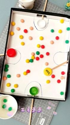 a close up of a board game on a table next to cups and spoons