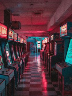 several arcade machines lined up in a room with checkered flooring and neon lights